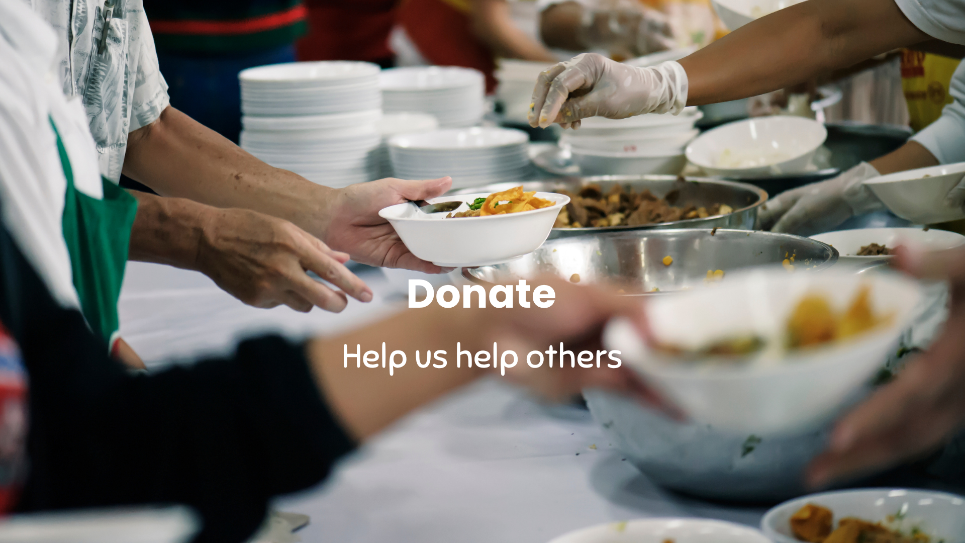 People serving food at a table with a 'Donate' text overlay.
